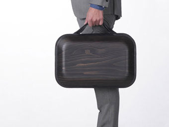 Close-up of businessman's hand holding wooden bag monacca